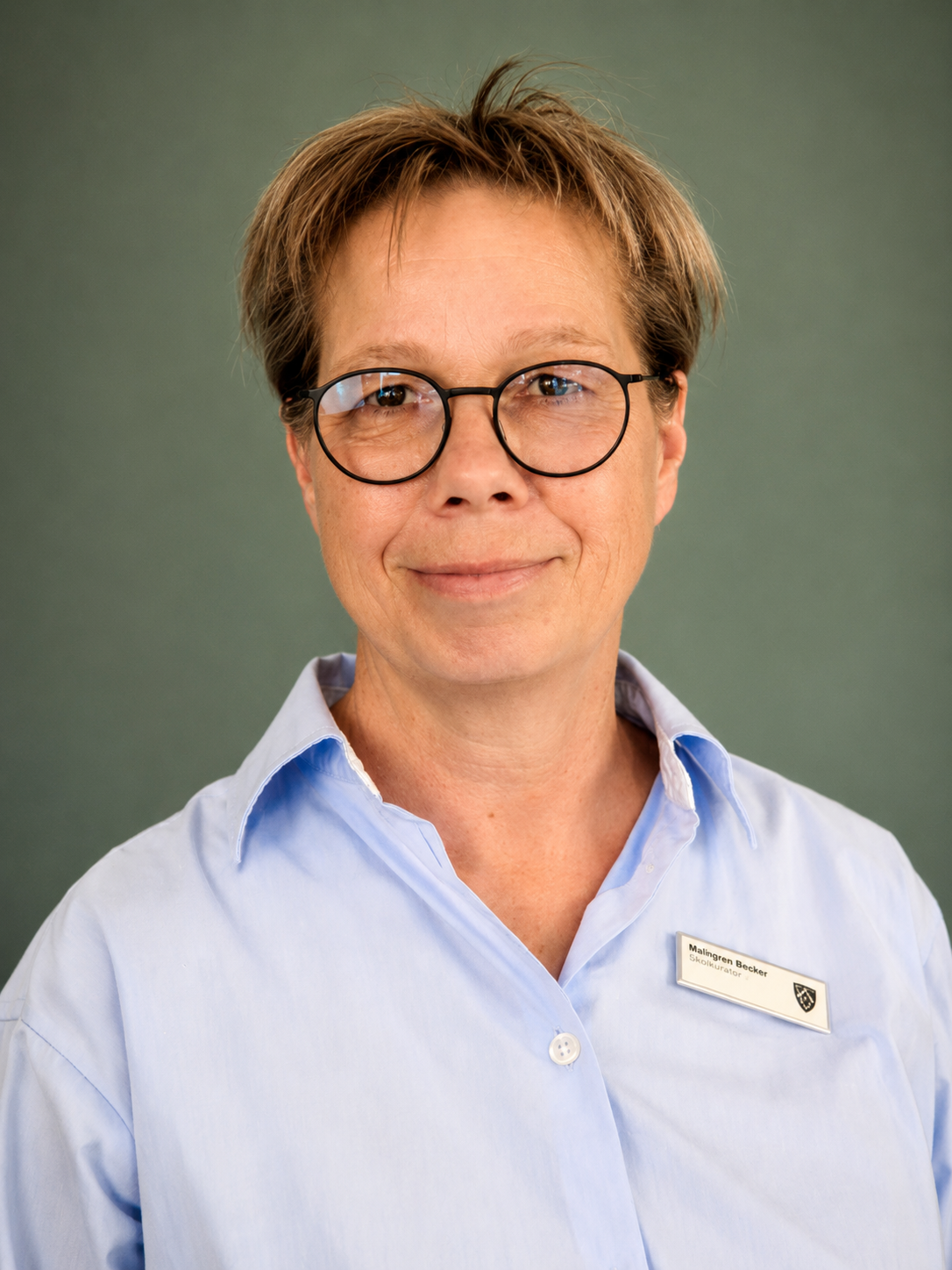 Porträtfoto einer Frau mit Brille in hellblauem Hemd mit Namensschild des Autohauses Auto Brehm.